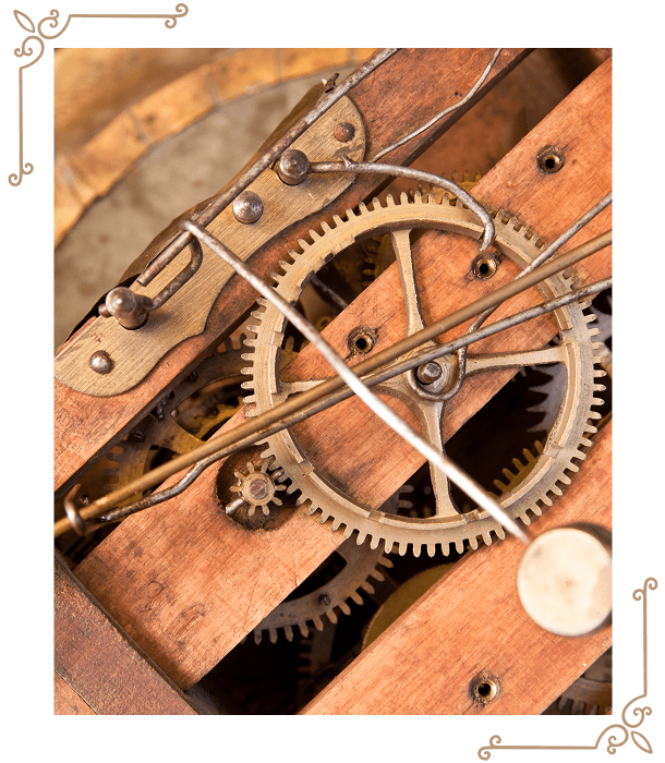 Close-up view of interlocking metal gears and rods inside a wooden clock mechanism, showing detailed components and craftsmanship.